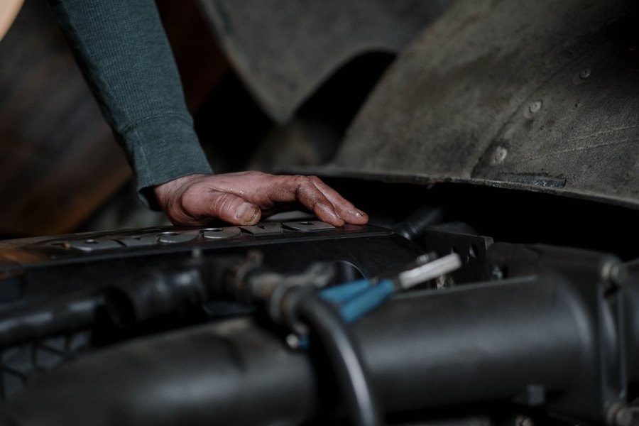 Main posée sur un cache moteur, passage de roue en arrière-plan